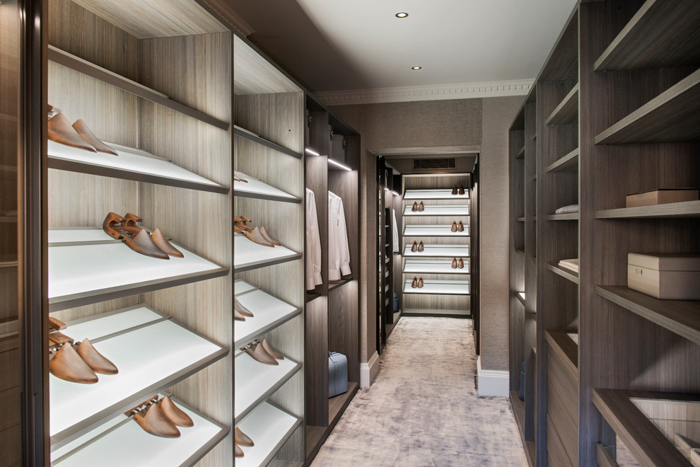 Design ideas for a contemporary men's dressing room in London with flat-panel cabinets, brown cabinets, carpet and beige floor.