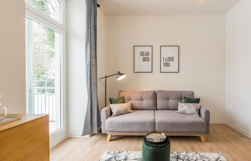 Kleines, Offenes Modernes Wohnzimmer mit weißer Wandfarbe, hellem Holzboden, freistehendem TV, braunem Boden, Tapetendecke und Tapetenwänden in Dresden