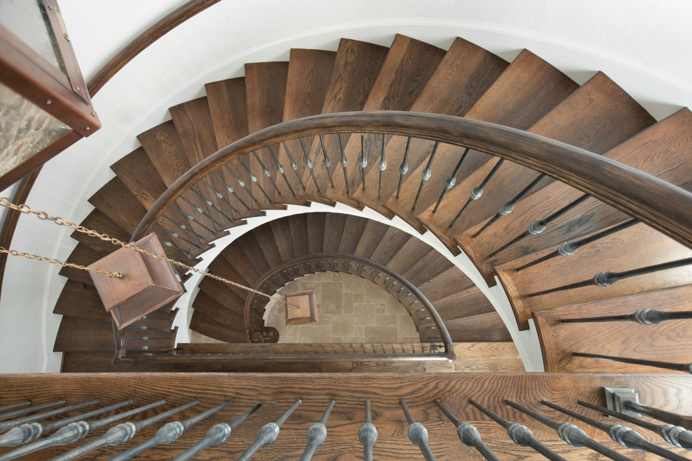 Photo of a large mediterranean wood spiral staircase in Other with wood risers.
