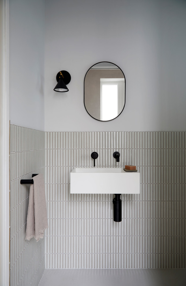 Inspiration for a small asian powder room in London with white walls, concrete floors, a wall-mount sink and grey floor.