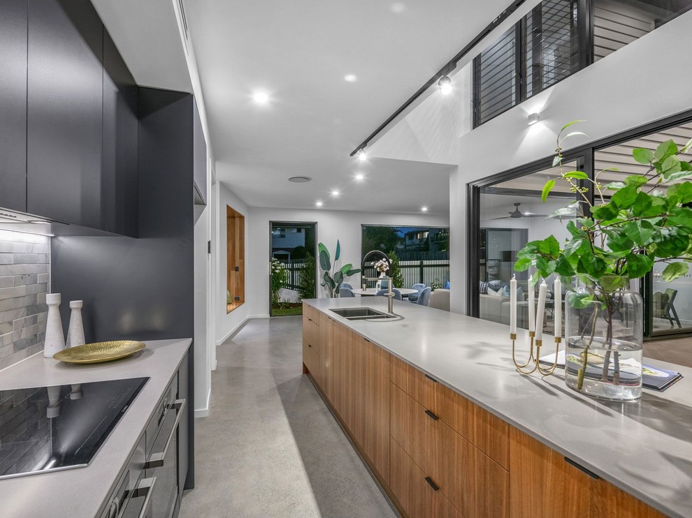Design ideas for a contemporary galley kitchen in Brisbane with an undermount sink, flat-panel cabinets, medium wood cabinets, grey splashback, concrete floors, with island, grey floor and grey benchtop.