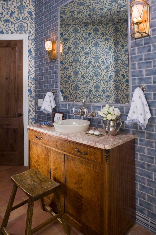 Mediterranean powder room in Denver with a vessel sink, medium wood cabinets, blue tile and subway tile.