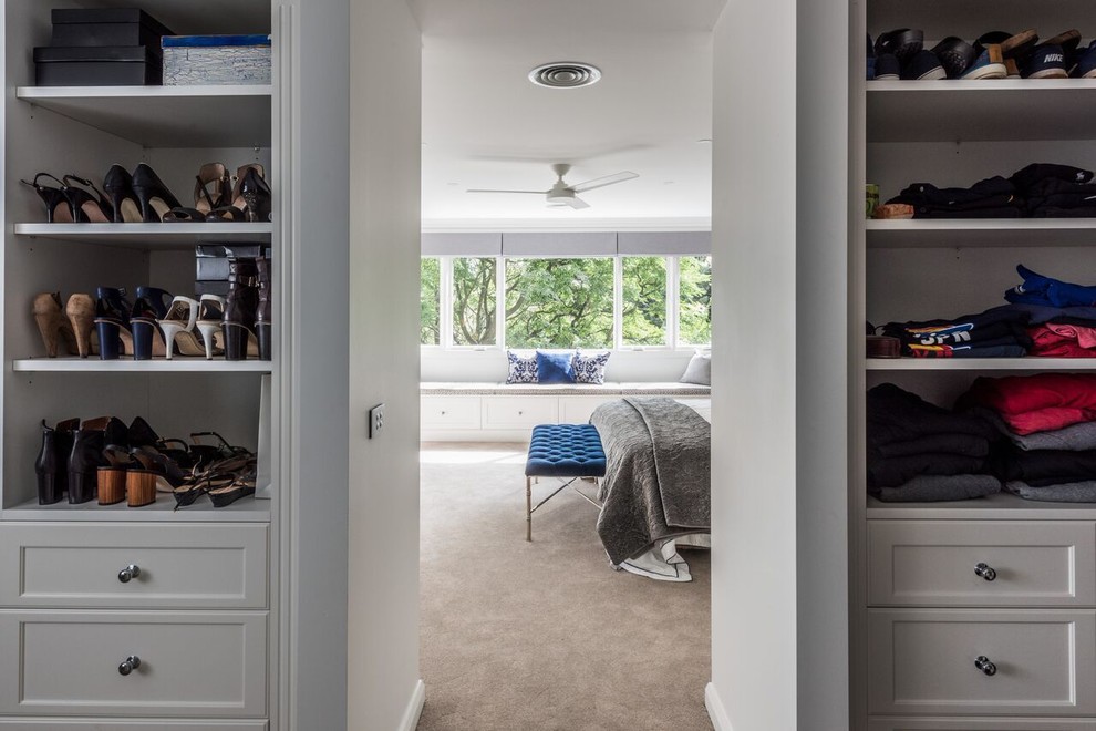 This is an example of a large traditional gender-neutral walk-in wardrobe with shaker cabinets, white cabinets, carpet and grey floor.