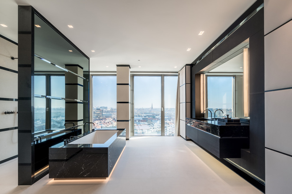 This is an example of a large contemporary master bathroom in Munich with flat-panel cabinets, black cabinets, an open shower, white floor, an open shower, black benchtops, black tile, an undermount tub and an undermount sink.