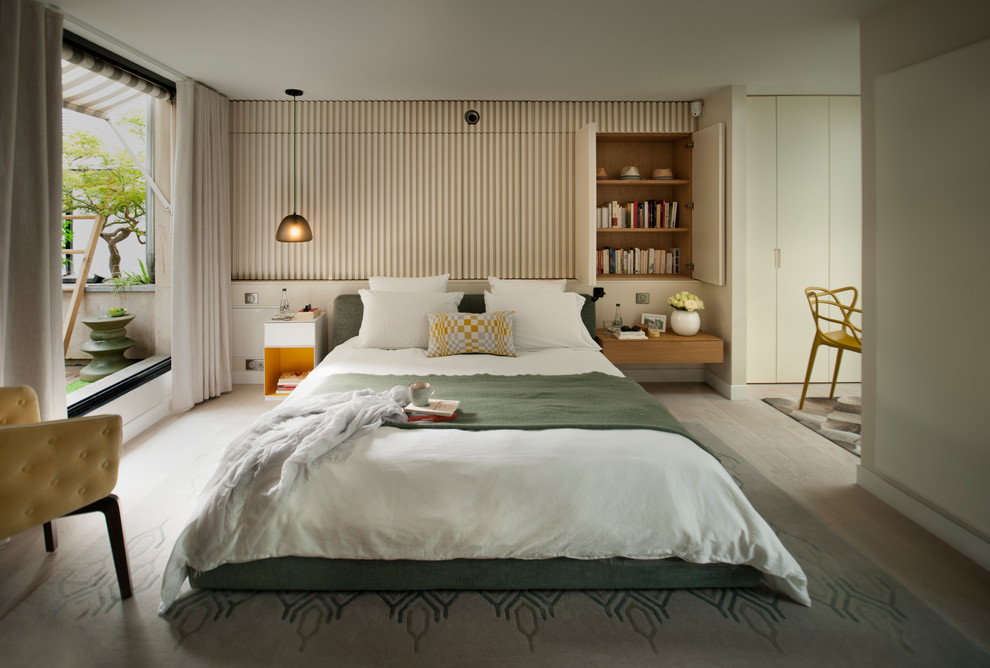 Photo of a contemporary bedroom in London with beige walls, light hardwood floors and beige floor.