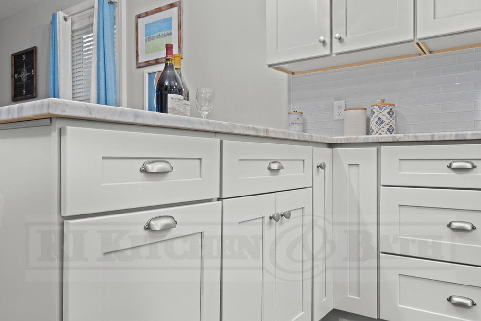Transitional medium tone wood floor eat-in kitchen photo in Providence with a farmhouse sink, shaker cabinets, gray cabinets, glass tile backsplash and a peninsula