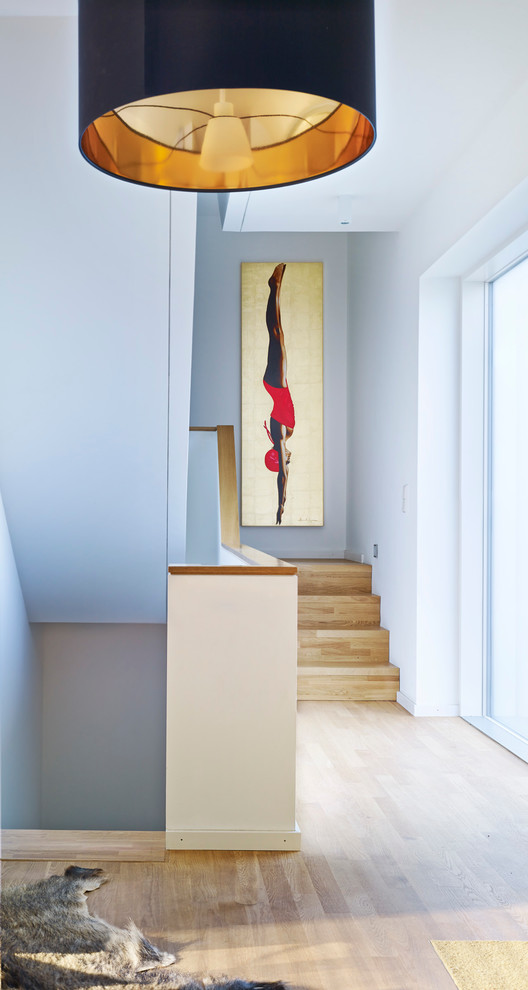 Design ideas for a mid-sized contemporary wood u-shaped staircase in Berlin with wood risers.