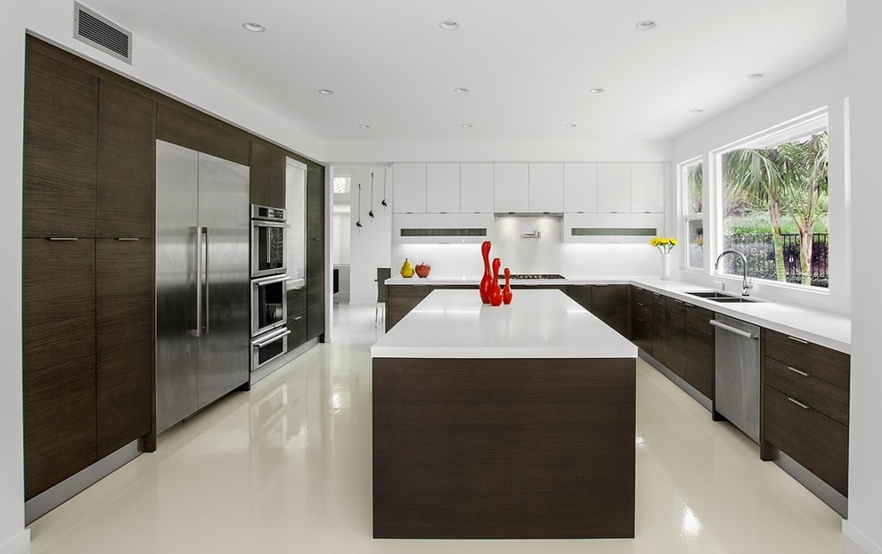 Large contemporary u-shaped eat-in kitchen in Orange County with a single-bowl sink, flat-panel cabinets, dark wood cabinets, quartz benchtops, white splashback, stainless steel appliances, concrete floors and with island.