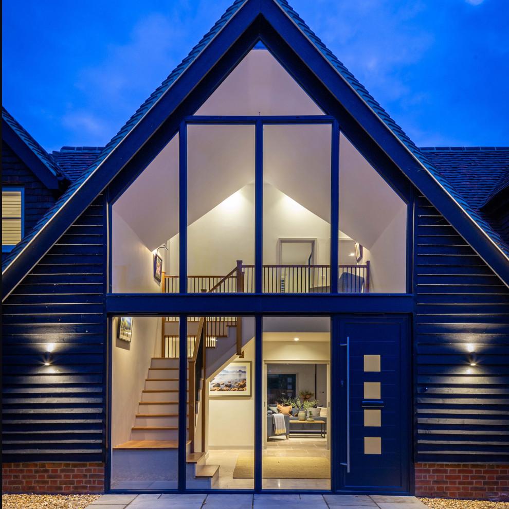 Example of a large classic two-story brick exterior home design in Oxfordshire with a mixed material roof