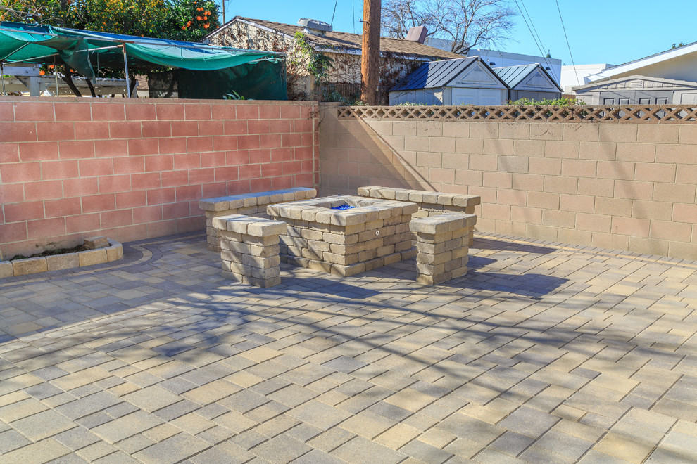 Mid-sized contemporary backyard patio in Los Angeles with a fire feature, brick pavers and no cover.