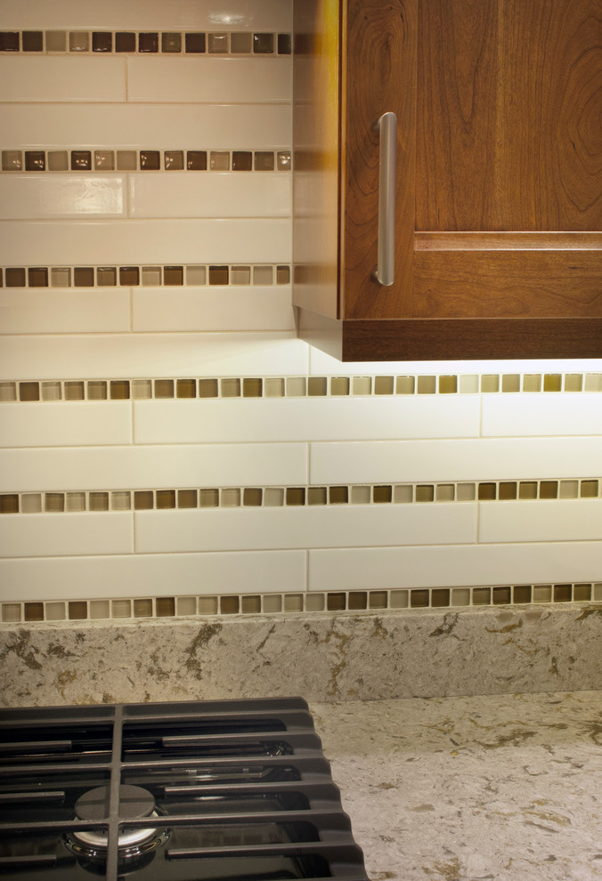 Small transitional u-shaped porcelain tile enclosed kitchen photo in Seattle with an undermount sink, recessed-panel cabinets, dark wood cabinets, quartz countertops, beige backsplash, cement tile backsplash, stainless steel appliances and no island