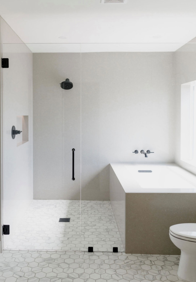 Réalisation d'une grande salle de bain principale minimaliste avec une baignoire d'angle, un espace douche bain, un mur blanc, tomettes au sol, une cabine de douche à porte battante et une fenêtre.