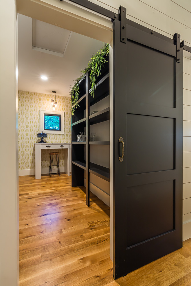 Kitchen pantry - large transitional medium tone wood floor kitchen pantry idea in Cedar Rapids with open cabinets, black cabinets and no island