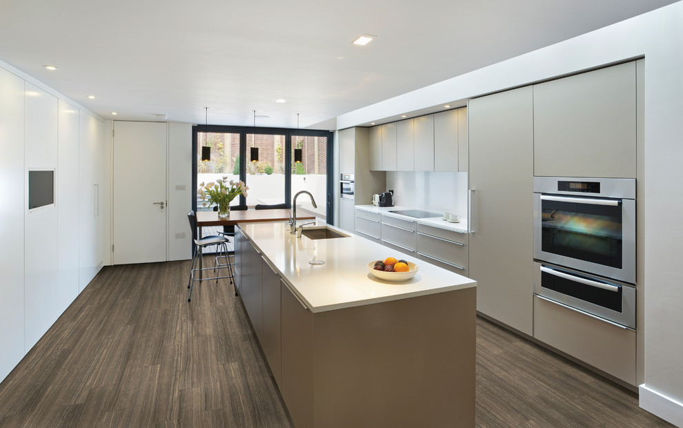 Mid-sized contemporary single-wall separate kitchen in Toronto with a drop-in sink, flat-panel cabinets, beige cabinets, quartz benchtops, white splashback, stainless steel appliances, porcelain floors and with island.