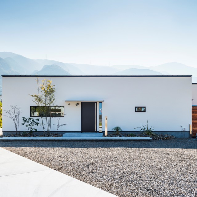 白の塗り壁に黒の窓枠と玄関が印象的 modern-exterior
