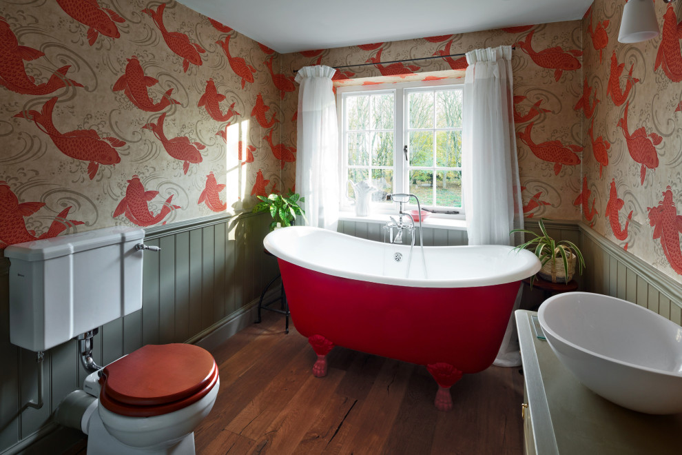 Mittelgroßes Landhaus Kinderbad mit Löwenfuß-Badewanne, Toilette mit Aufsatzspülkasten, bunten Wänden, dunklem Holzboden, Einbauwaschbecken, braunem Boden und freistehendem Waschtisch in Oxfordshire