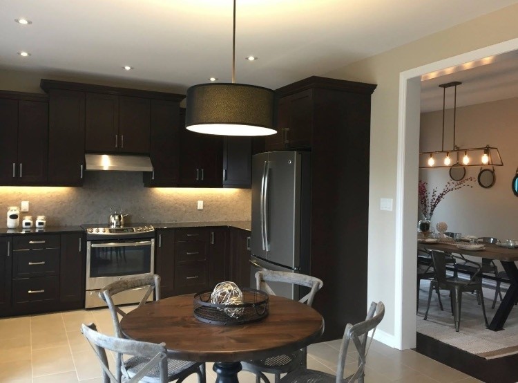 Inspiration for a rustic ceramic tile open concept kitchen remodel with a farmhouse sink, shaker cabinets, dark wood cabinets, granite countertops, brown backsplash, marble backsplash, stainless steel appliances and no island