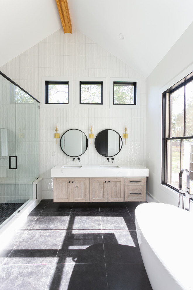 Photo of an expansive farmhouse ensuite bathroom in Charleston with shaker cabinets, white cabinets, a freestanding bath, white tiles, metro tiles, white walls, light hardwood flooring, engineered stone worktops, beige floors, white worktops, double sinks, a floating vanity unit and exposed beams.