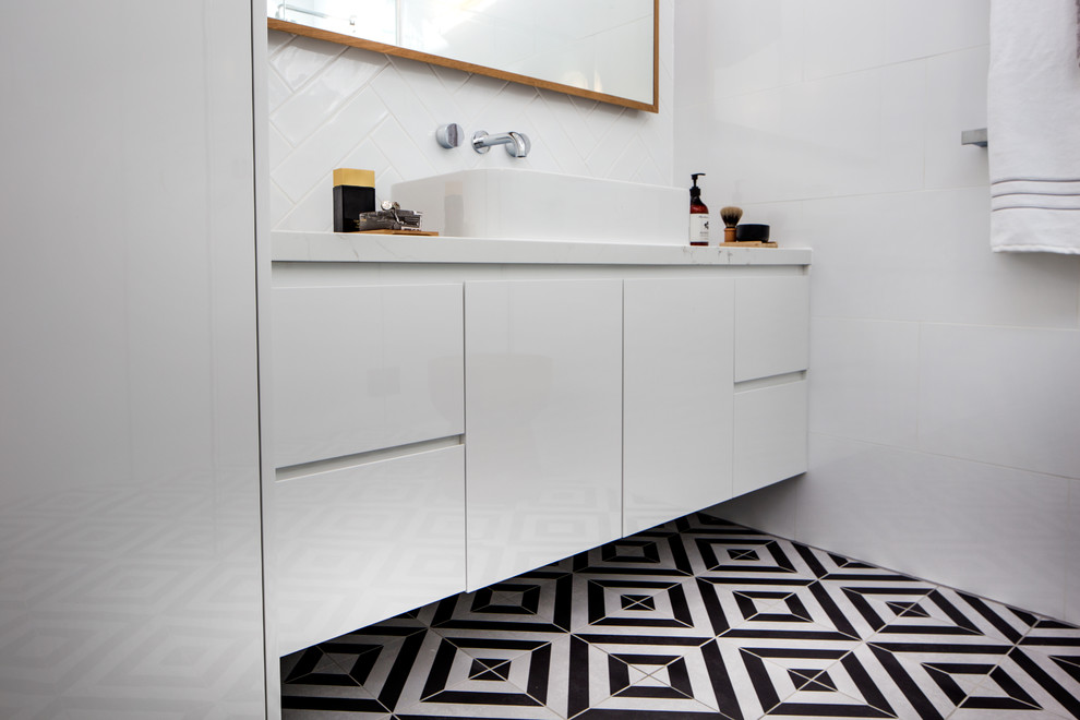 This is an example of a mid-sized contemporary 3/4 bathroom in Melbourne with furniture-like cabinets, white cabinets, a curbless shower, a one-piece toilet, black and white tile, ceramic tile, white walls, porcelain floors, a vessel sink and engineered quartz benchtops.