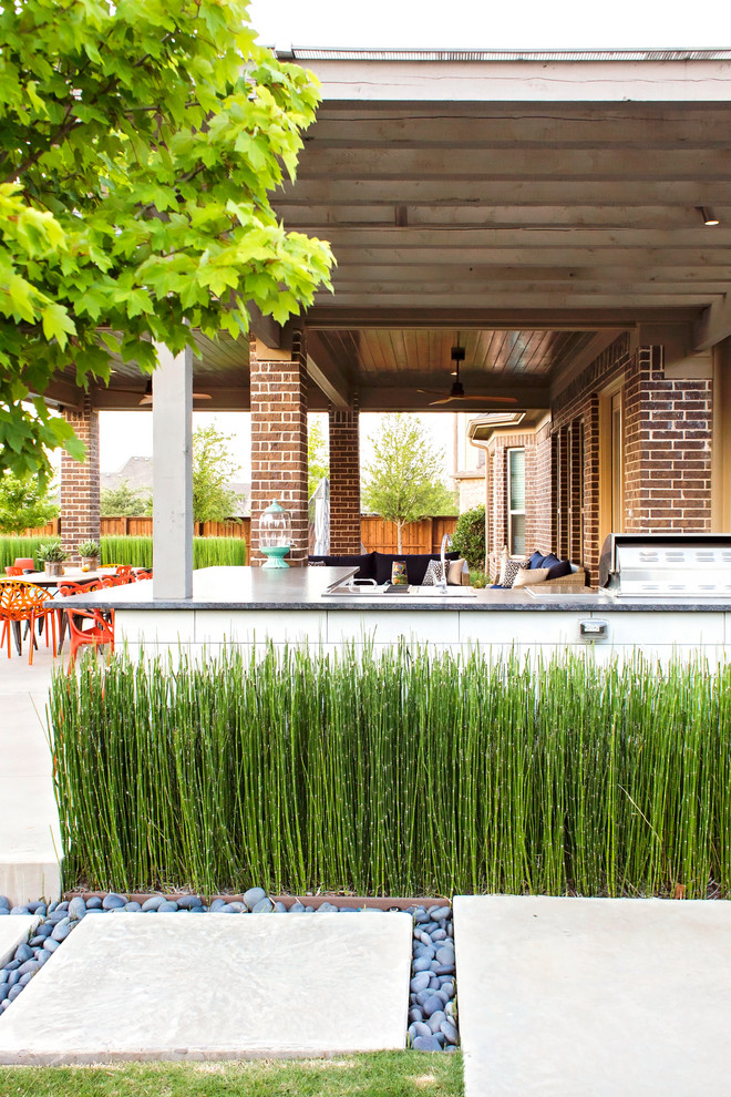 Photo of a large eclectic backyard patio in Dallas with an outdoor kitchen, concrete pavers and a pergola.