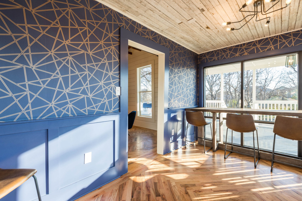 Immagine di un atelier minimalista di medie dimensioni con pareti blu, scrivania autoportante, pavimento marrone e carta da parati