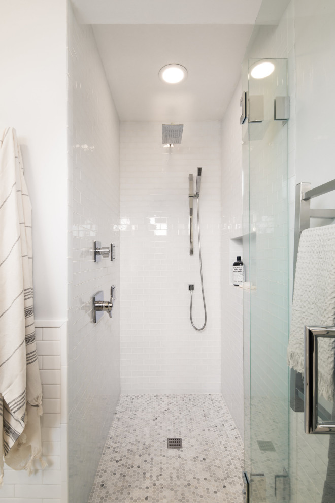 This is an example of a mid-sized transitional wet room bathroom in Seattle with flat-panel cabinets, dark wood cabinets, a one-piece toilet, marble floors, a trough sink, grey floor, a hinged shower door, a single vanity, a floating vanity, white tile, glass tile and a niche.