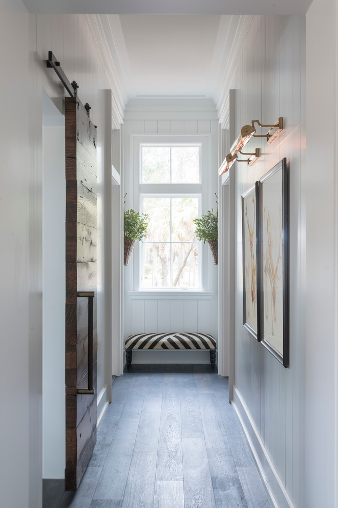 Photo of a mid-sized country hallway in Charleston with white walls, dark hardwood floors and blue floor.