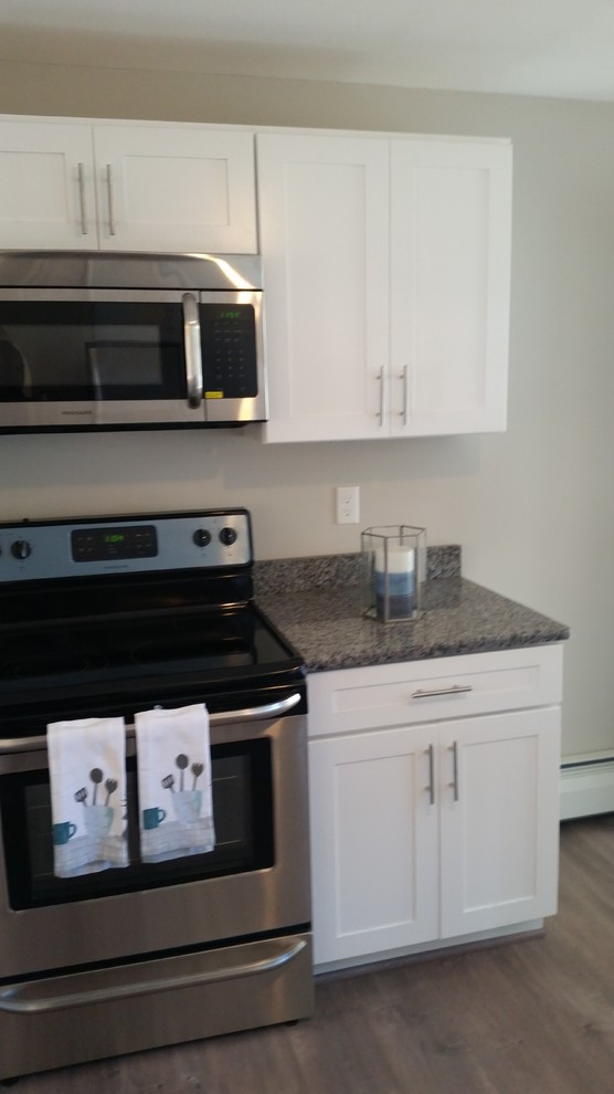 Example of a mid-sized transitional l-shaped home design design in Providence with a single-bowl sink, shaker cabinets, white cabinets, granite countertops, stainless steel appliances and a peninsula