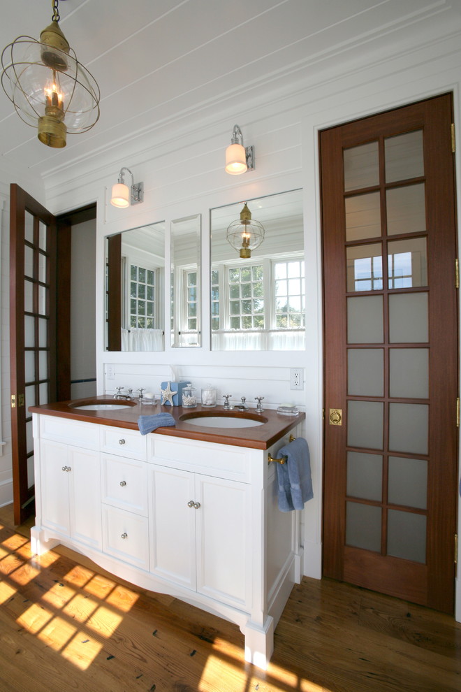 Traditional bathroom in Boston with an undermount sink and wood benchtops.