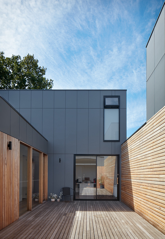 Large contemporary two-storey grey townhouse exterior in Melbourne with wood siding, a flat roof and a metal roof.