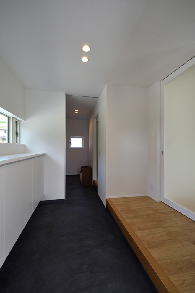 Mid-sized modern entry hall in Other with white walls, a sliding front door, a dark wood front door, black floor, wallpaper and wallpaper.