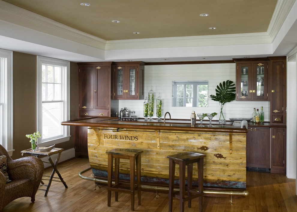 Inspiration for a country galley seated home bar in Boston with shaker cabinets, dark wood cabinets, white splashback and medium hardwood floors.