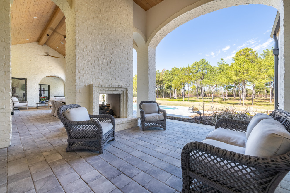 Large eclectic stone porch photo in Houston with a roof extension