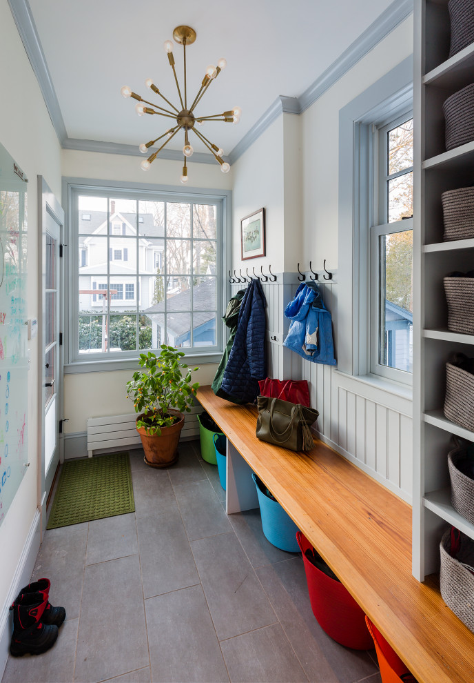 Inspiration for a mid-sized eclectic mudroom in Boston with white walls, porcelain floors, a single front door, a blue front door, grey floor and decorative wall panelling.