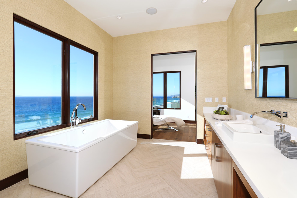 Inspiration for a contemporary bathroom in Orange County with an integrated sink, flat-panel cabinets, medium wood cabinets, a freestanding tub, a corner shower and travertine floors.