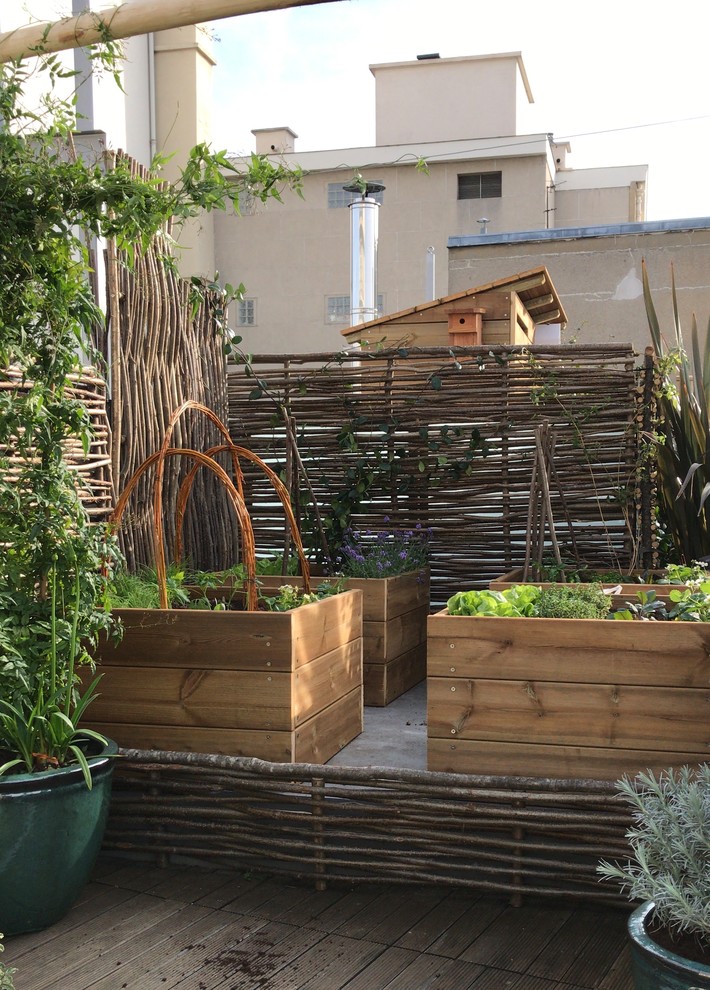 This is an example of a large country rooftop deck in Paris with a container garden and no cover.