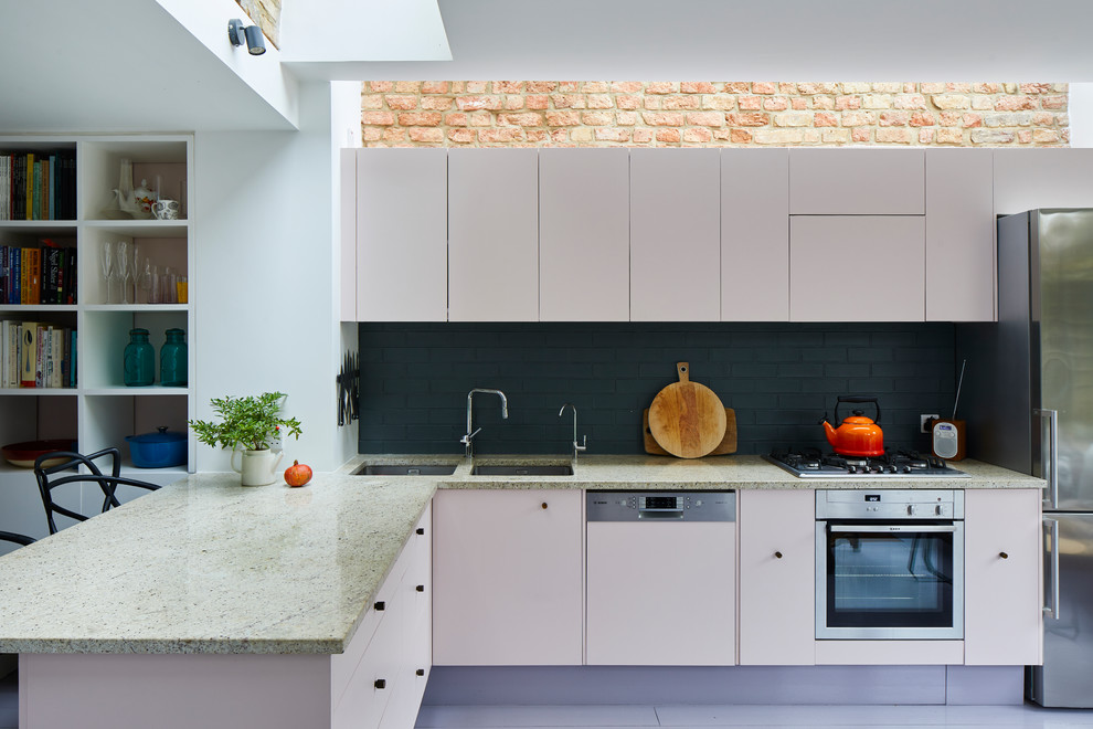 Design ideas for a contemporary l-shaped kitchen in London with a double-bowl sink, flat-panel cabinets, beige cabinets, black splashback, subway tile splashback, stainless steel appliances, a peninsula and multi-coloured benchtop.
