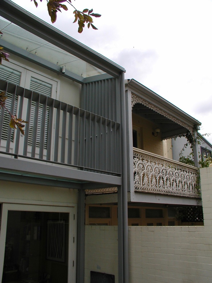 Small contemporary three-storey glass multi-coloured house exterior in Sydney with a gable roof and a mixed roof.