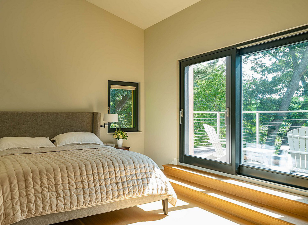 Contemporary master bedroom in Boston with light hardwood floors.