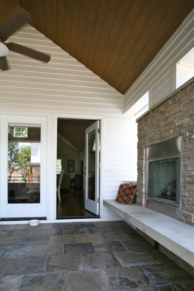 Photo of a mid-sized contemporary backyard verandah in Houston with a fire feature, tile and a roof extension.