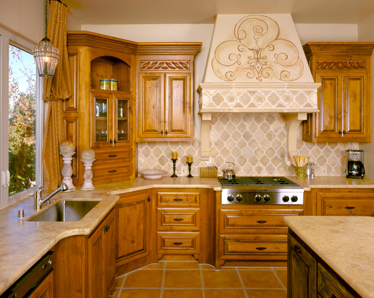 Mountain style l-shaped terra-cotta tile eat-in kitchen photo in Sacramento with a single-bowl sink, raised-panel cabinets, medium tone wood cabinets, granite countertops, beige backsplash, ceramic backsplash, paneled appliances and an island