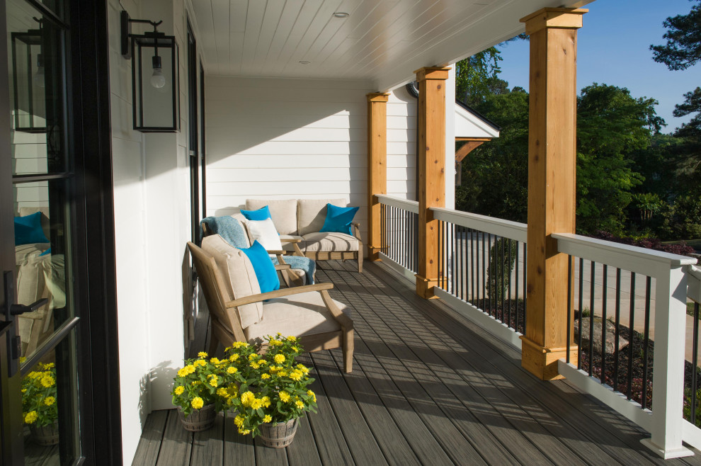 Réalisation d'un grand porche d'entrée de maison avant champêtre avec une terrasse en bois, une extension de toiture et un garde-corps en matériaux mixtes.