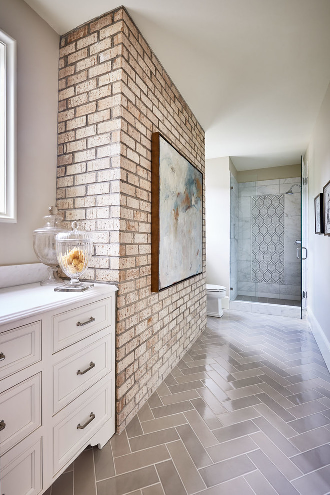 This is an example of a mid-sized country master bathroom in Charlotte with raised-panel cabinets, white cabinets, a curbless shower, a two-piece toilet, black tile, subway tile, beige walls, light hardwood floors, a drop-in sink, solid surface benchtops, grey floor and a hinged shower door.