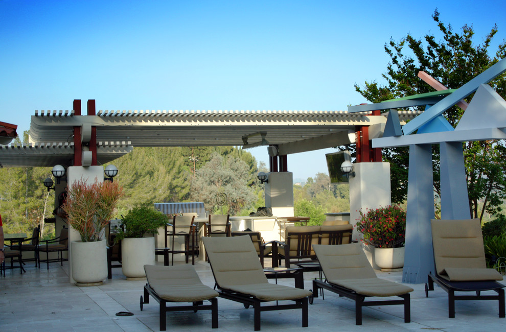 Large contemporary backyard patio in Los Angeles with an outdoor kitchen, natural stone pavers and a pergola.