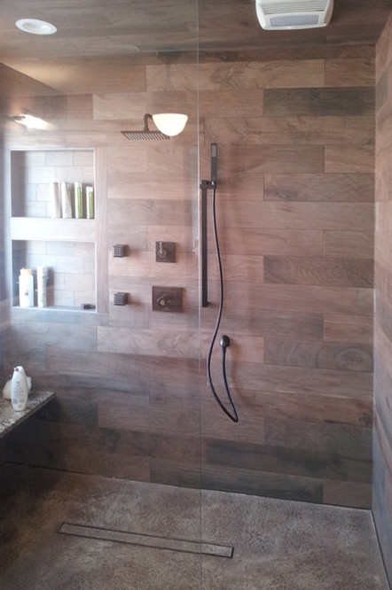 Large country master bathroom in Cedar Rapids with an open shower, brown tile, ceramic tile, brown walls, pebble tile floors, grey floor and a hinged shower door.
