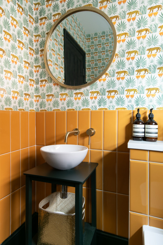 This is an example of a contemporary bathroom in Buckinghamshire with open cabinets, black cabinets, orange tile, multi-coloured walls, a vessel sink and wallpaper.