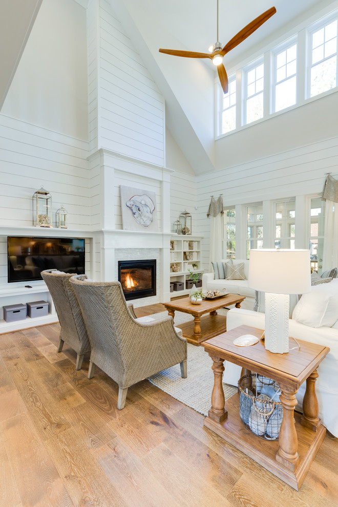 Large open concept medium tone wood floor and brown floor family room photo in Other with white walls, a standard fireplace, a stone fireplace and a media wall