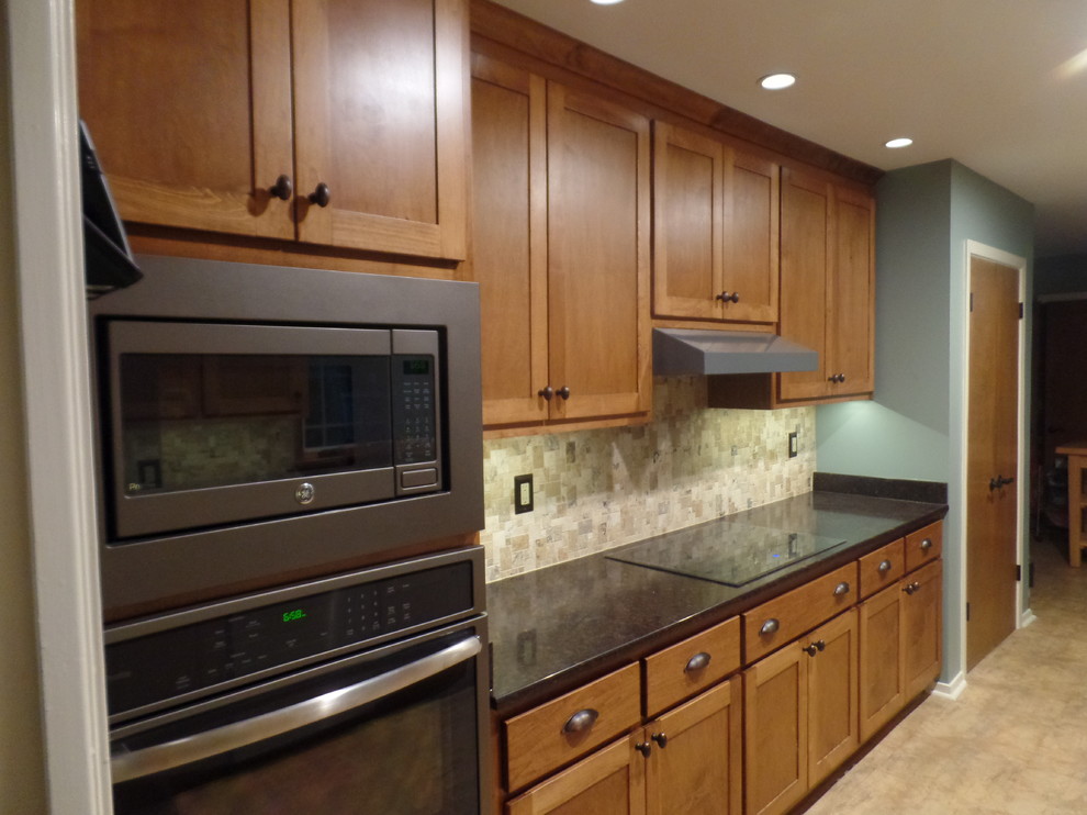 Mid-sized transitional galley eat-in kitchen photo with an undermount sink, shaker cabinets, medium tone wood cabinets, quartz countertops, multicolored backsplash, travertine backsplash, colored appliances and no island