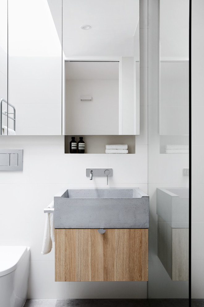 Photo of a small contemporary master bathroom in Melbourne with grey cabinets, a curbless shower, a wall-mount toilet, white tile, ceramic tile, white walls, ceramic floors, a wall-mount sink, concrete benchtops, grey floor, an open shower, grey benchtops and flat-panel cabinets.