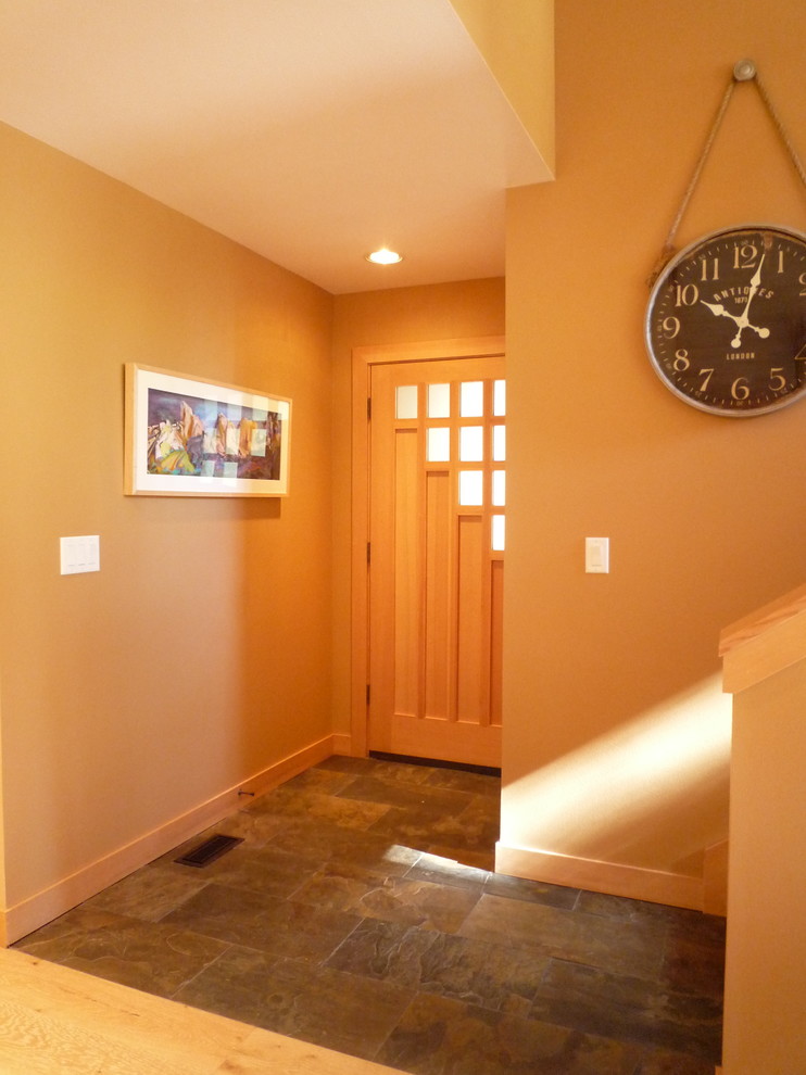This is an example of a mid-sized country foyer in Portland with beige walls, slate floors, a single front door and a light wood front door.